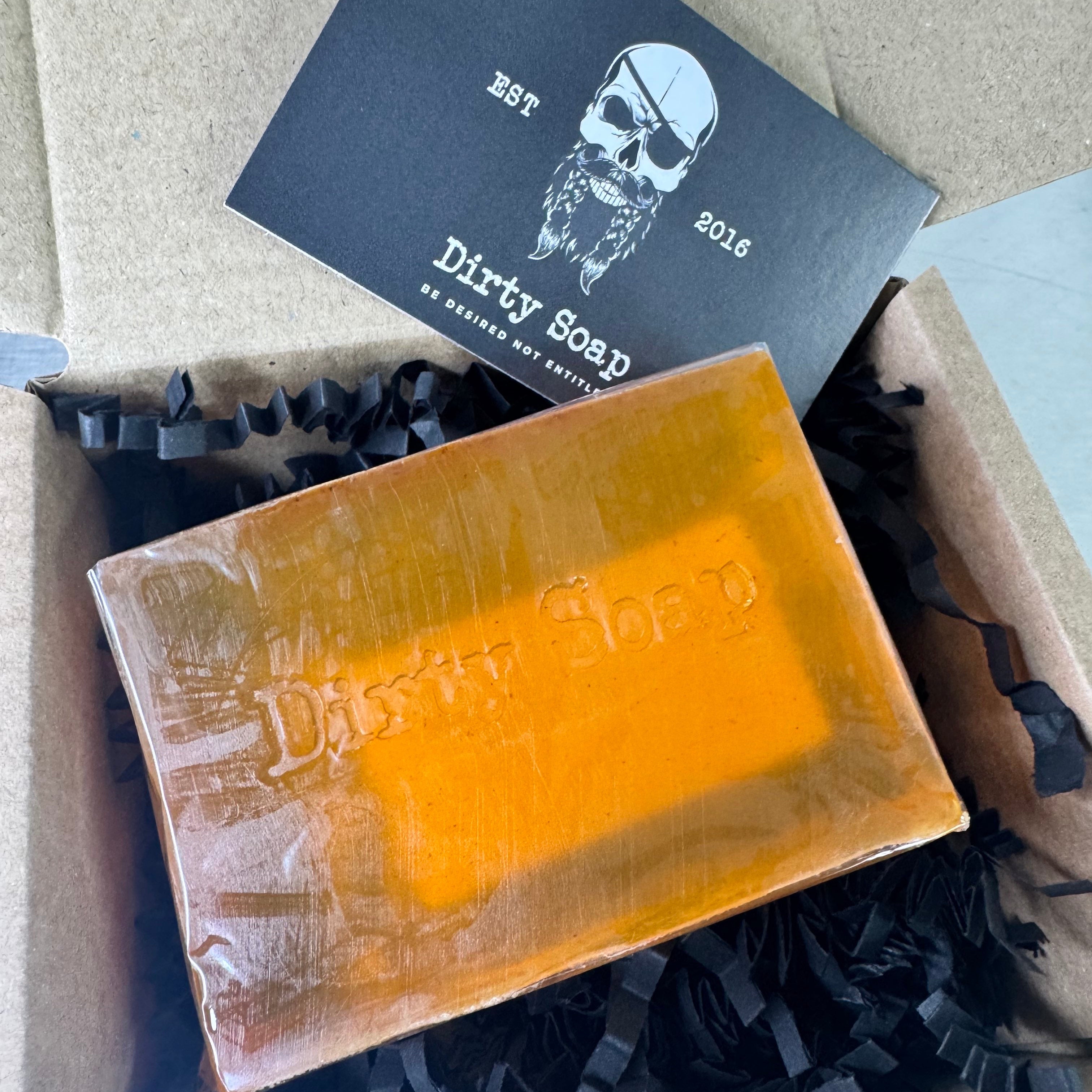 Bar of soap with 'Dirty Soap' branding on a black card with a skull design.